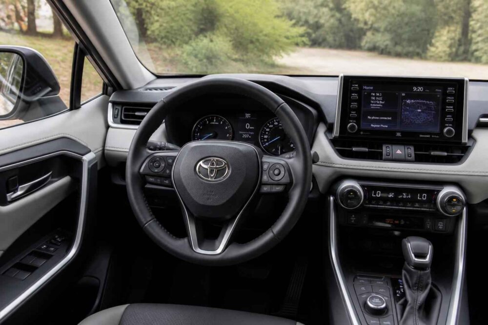 Kokpit samochodu Toyota z centralnym ekranem multimedialnym Kierownica Toyota, cyfrowe zegary, ekran multimedialny i automatyczna skrzynia biegów we wnętrzu auta