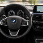 Kierownica BMW, zegary, ekran nawigacji i panel klimatyzacji w kokpicie samochodu