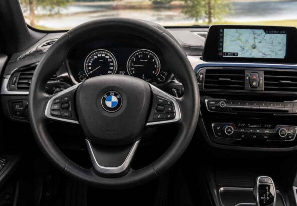 Kierownica BMW, zegary, ekran nawigacji i panel klimatyzacji w kokpicie samochodu