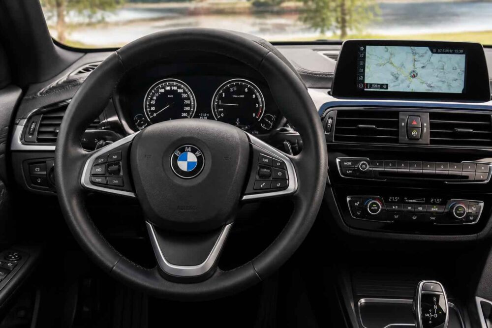 Kierownica BMW, zegary, ekran nawigacji i panel klimatyzacji w kokpicie samochodu